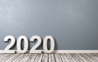 large 2020 numbers on a light gray wood floor in front of light blue wall
